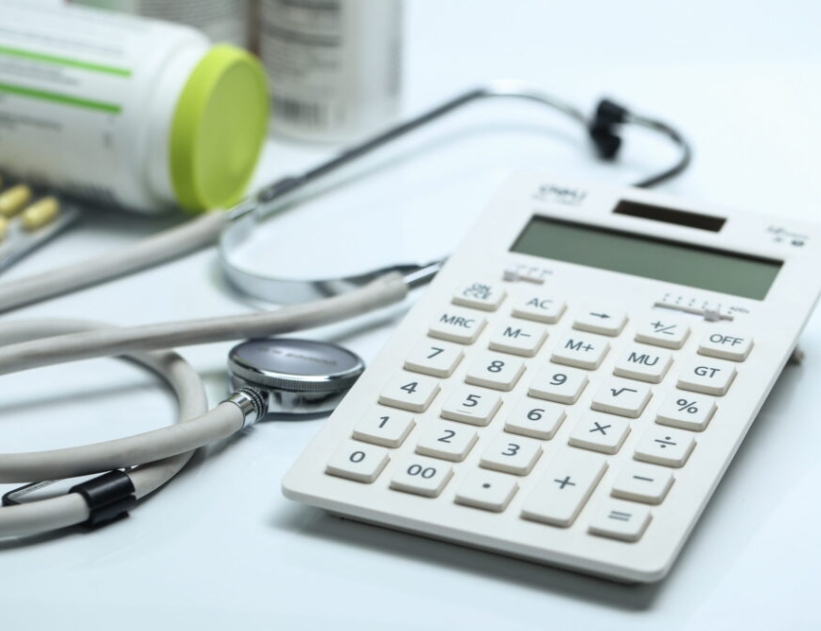 calculator, stethoscope and medicine bottles on white background